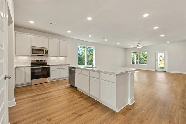 a kitchen with a refrigerator and a stove top oven