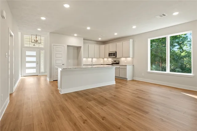 a view of kitchen with wooden floor and electronic appliances
