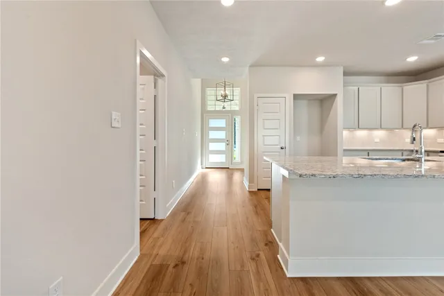 a view of a kitchen with kitchen island wooden floor center island and stainless steel appliances