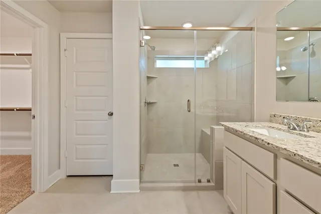 a bathroom with a shower sink and mirror