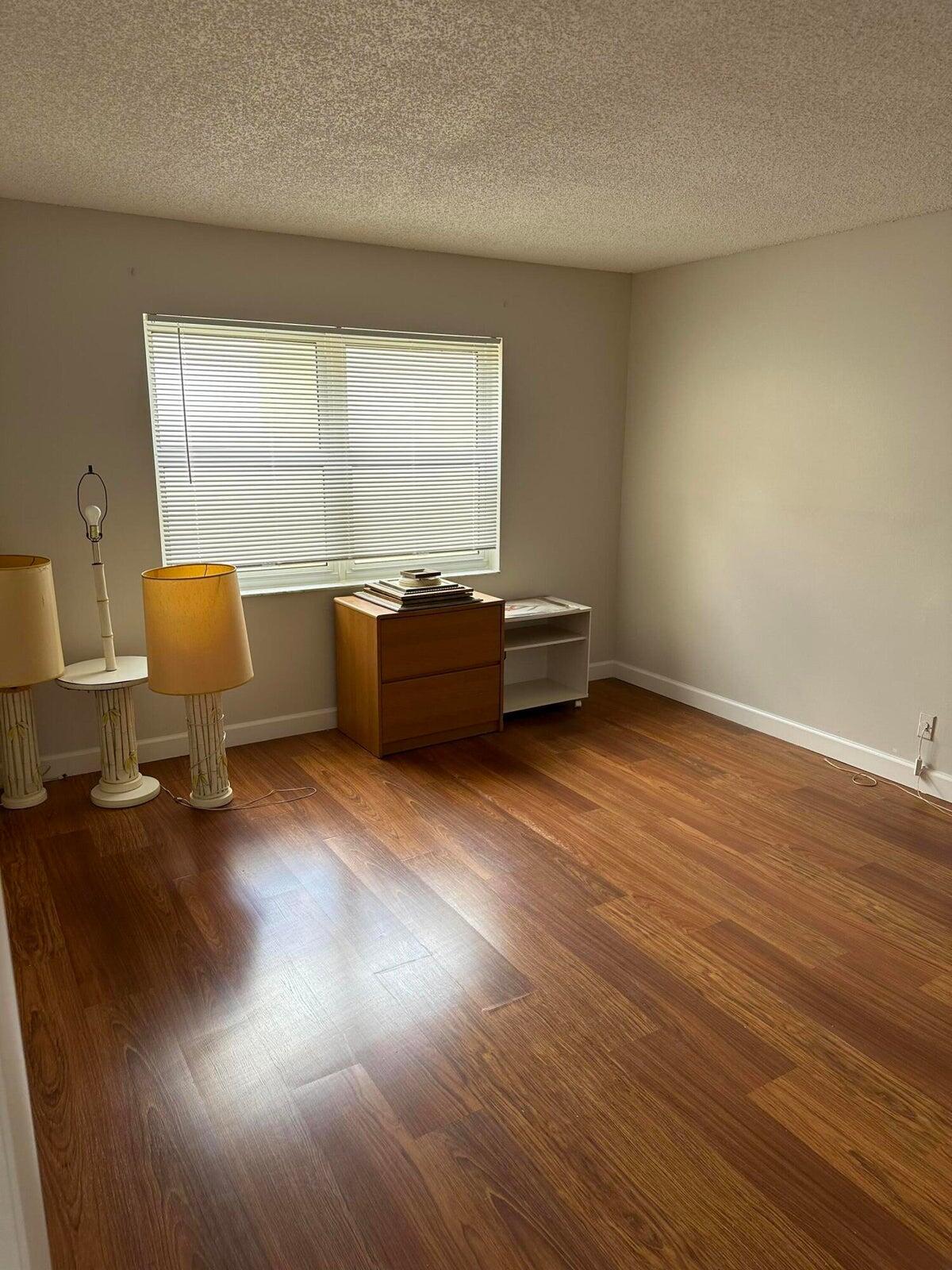 9355 Southwest 8th Street, Unit 421 Boca Raton, FL 33428 - Photo 11 of 20 a room with wooden floor and furniture