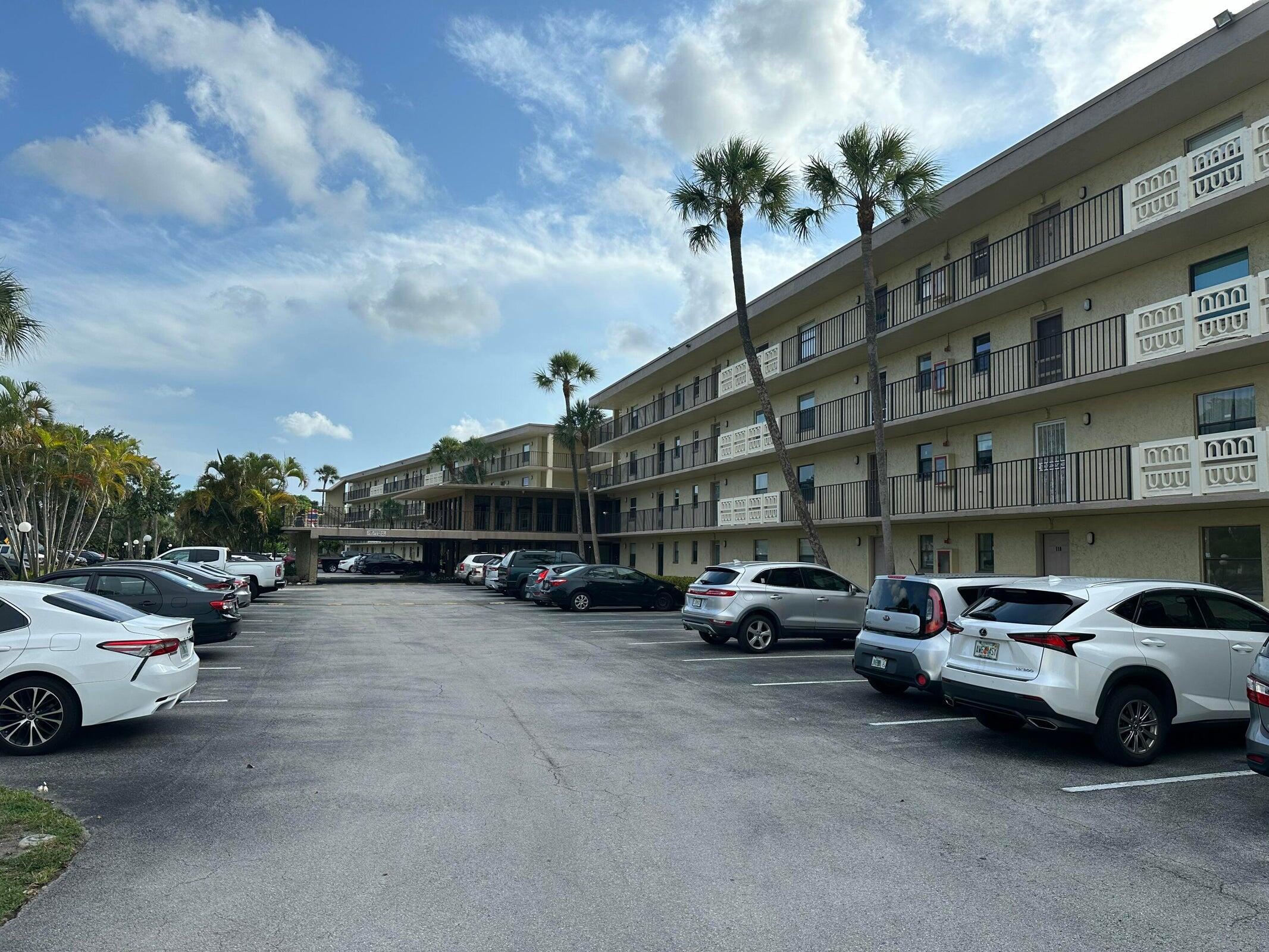 9355 Southwest 8th Street, Unit 421 Boca Raton, FL 33428 - Photo 16 of 20 a view of cars parked in front of a building