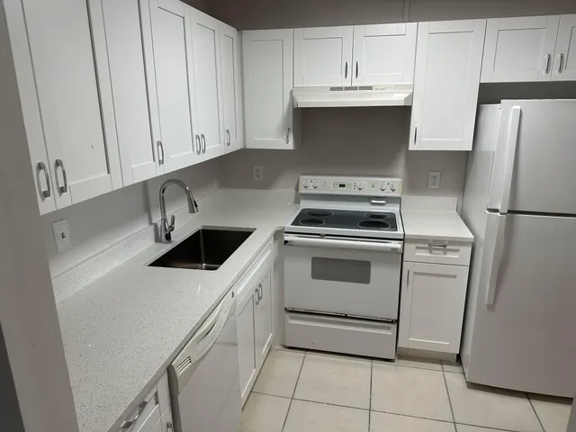 a white stove top oven sitting inside of a kitchen