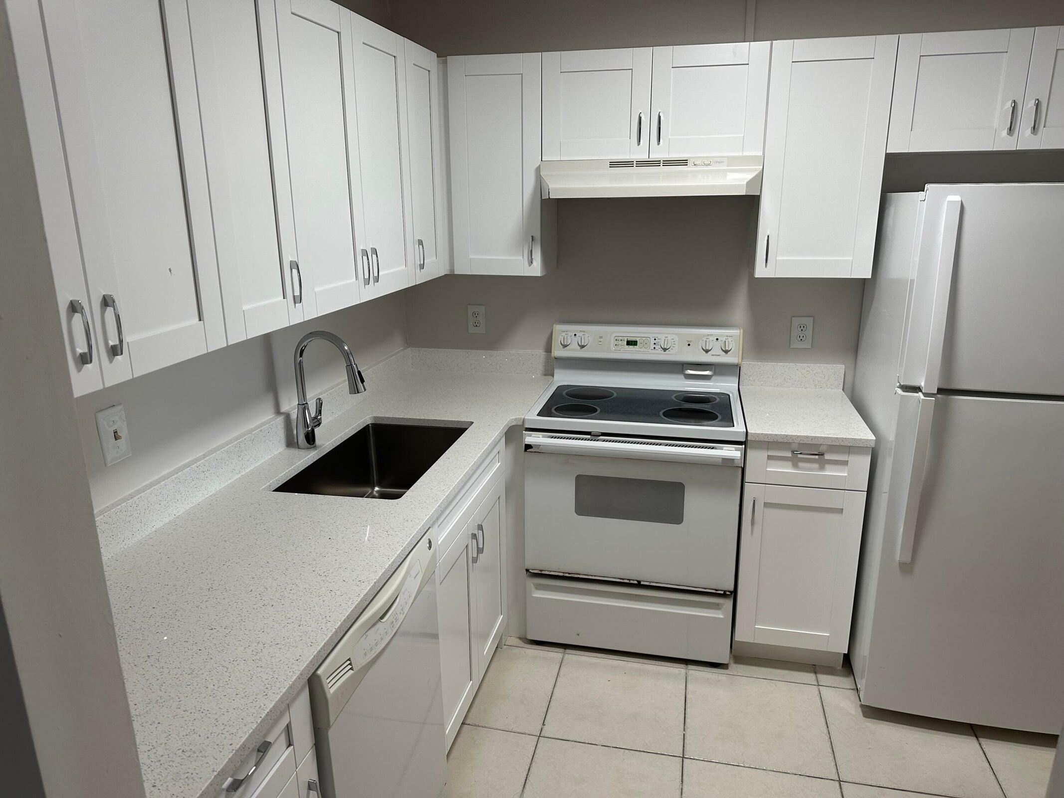 9355 Southwest 8th Street, Unit 421 Boca Raton, FL 33428 - Photo 3 of 20 a white stove top oven sitting inside of a kitchen