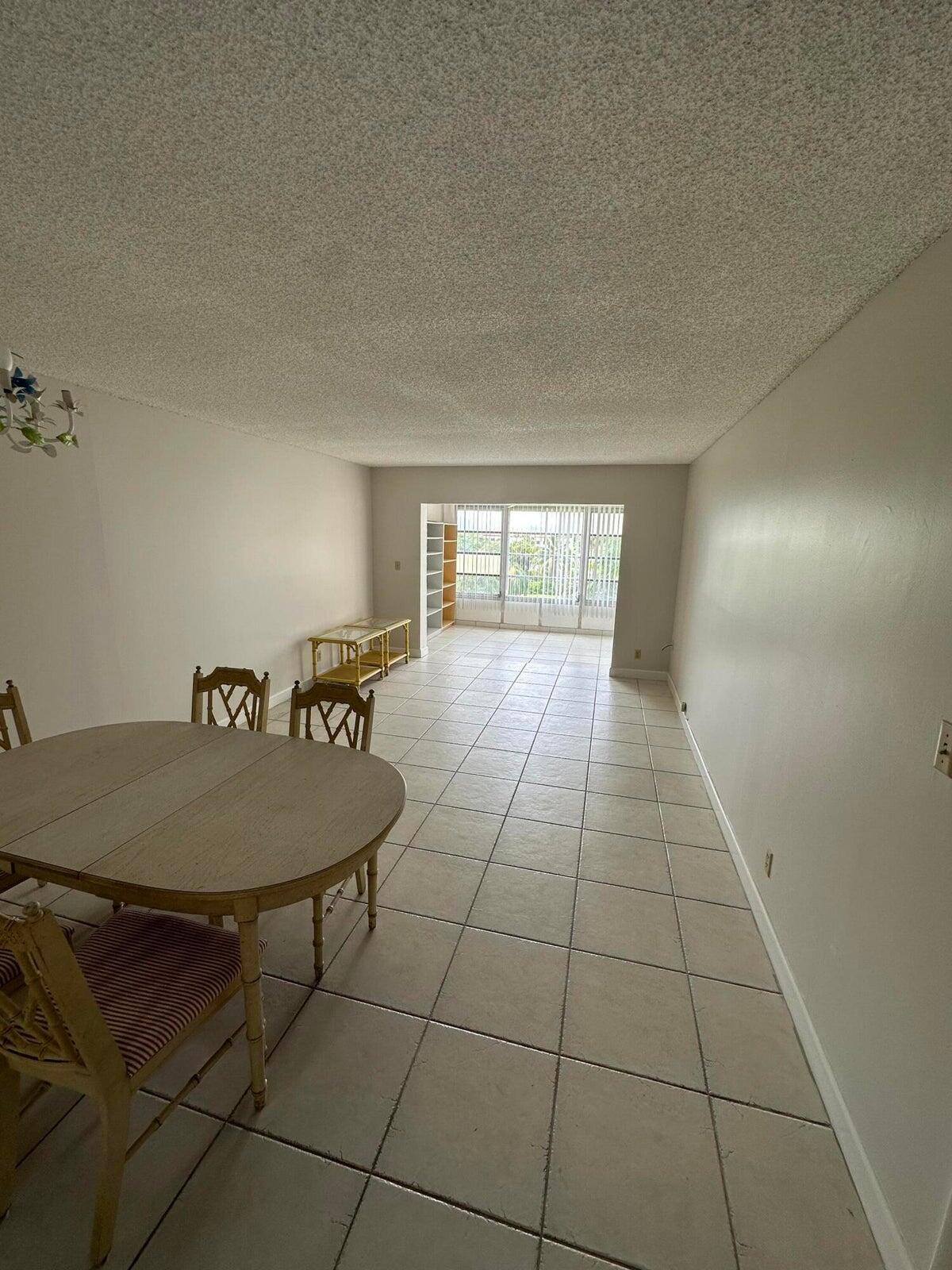 9355 Southwest 8th Street, Unit 421 Boca Raton, FL 33428 - Photo 5 of 20 a dining room with a table and chairs