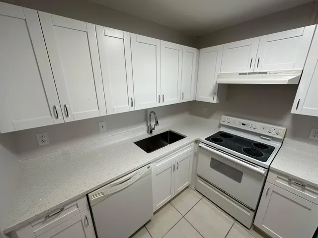 a kitchen with white cabinets and white appliances