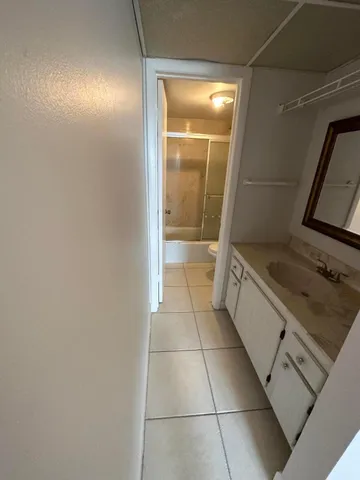 a bathroom with a granite countertop sink a toilet and a mirror