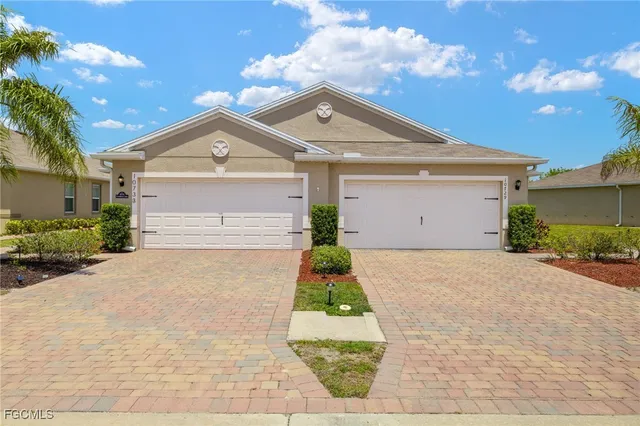 a front view of a house with a yard and garage