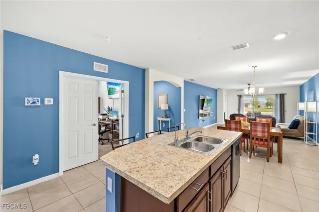 a view of kitchen island a sink granite counter tops and living room view