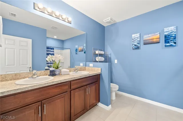 a bathroom with a granite countertop sink a toilet and a mirror