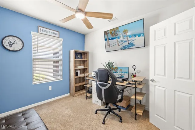 a view of a workspace with furniture and a window