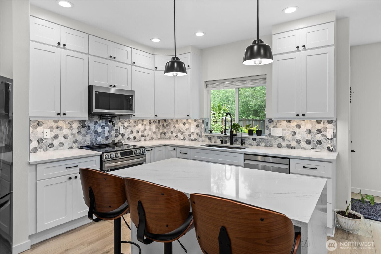 15325 Sunset Road Bothell, WA 98012 - Photo 7 of 40 a kitchen with stainless steel appliances a stove a sink a microwave a center island and a refrigerator
