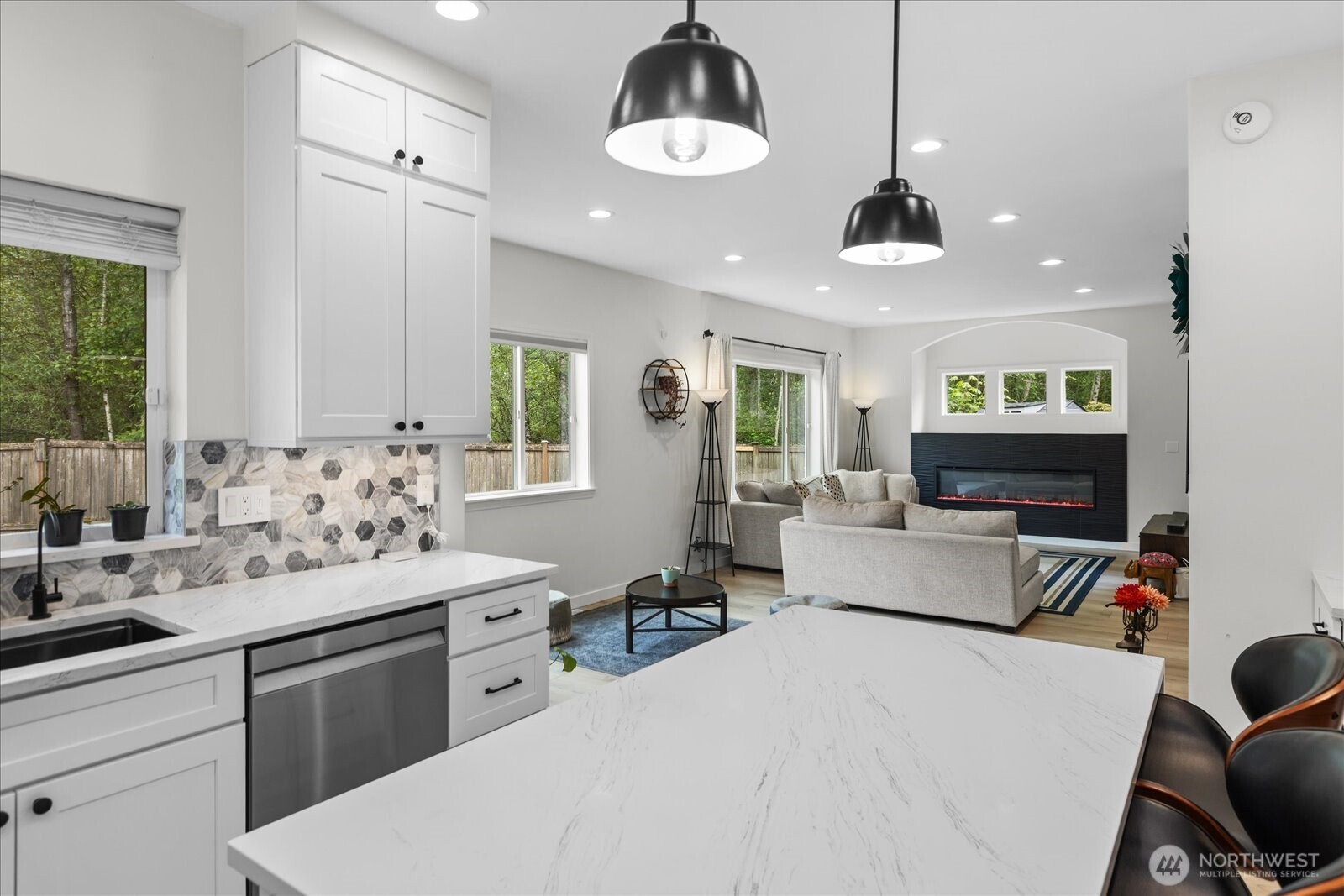 15325 Sunset Road Bothell, WA 98012 - Photo 9 of 40 a kitchen with stainless steel appliances a stove a sink a dining table and chairs with wooden floor