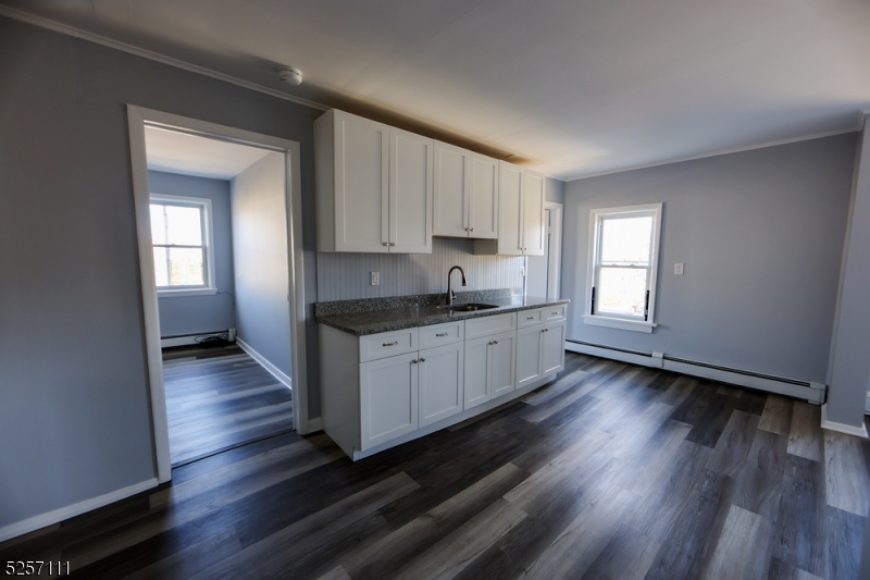 174 Main Street, Unit 2L Franklin, NJ 07416 - Photo 3 of 11 a kitchen with wooden floors and white cabinets