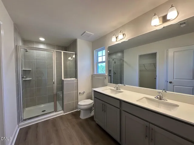 a bathroom with a double vanity sink toilet and shower