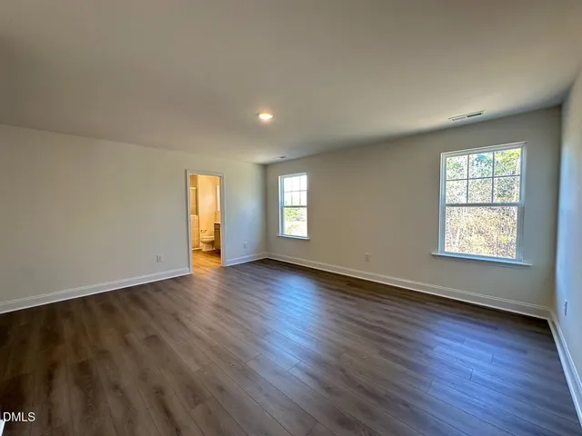 an empty room with wooden floor and window