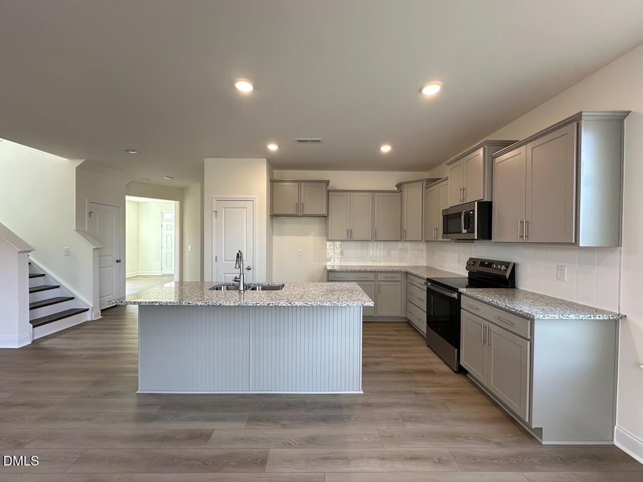 4961 Trout Crst Court Raleigh, NC 27604 - Photo 6 of 25 a large kitchen with stainless steel appliances granite countertop a large counter top and a stove
