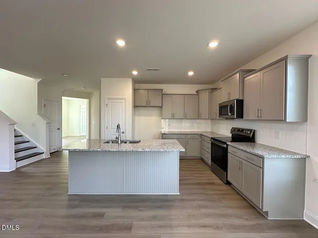 a large kitchen with stainless steel appliances granite countertop a large counter top and a stove