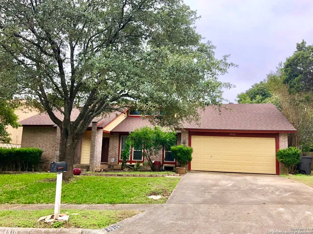 a front view of a house with a yard and trees