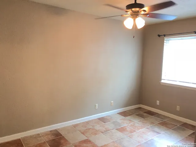 a view of a room with a chandelier fan and a window