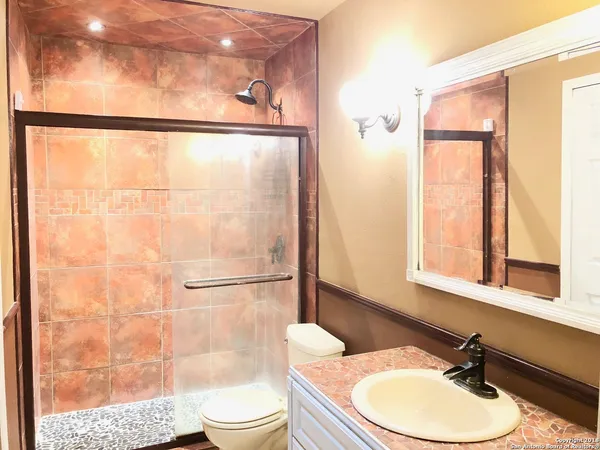 a bathroom with a sink a toilet and shower