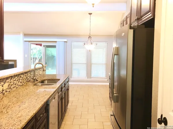 a bathroom with a granite countertop sink a mirror and shower