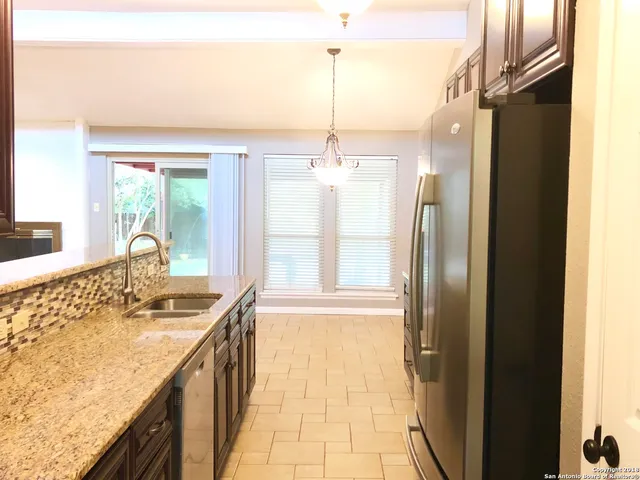 a bathroom with a granite countertop sink a mirror and shower