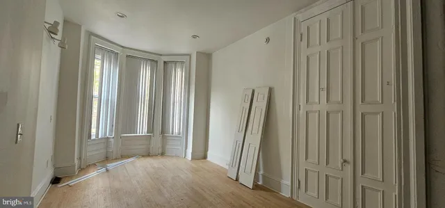 an empty room with wooden floor and a window