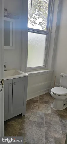 a bathroom with a toilet a sink and a window