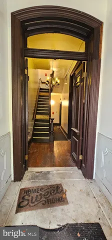 a view of a hallway with wooden floor and a fireplace
