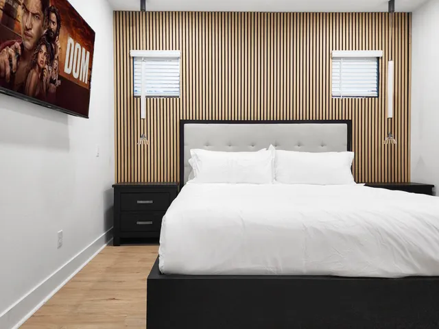 a bedroom with a bed and painting on the wall