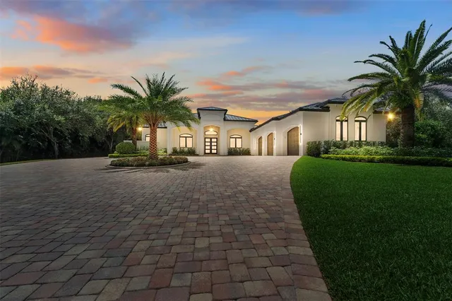a front view of a house with a yard and potted plants