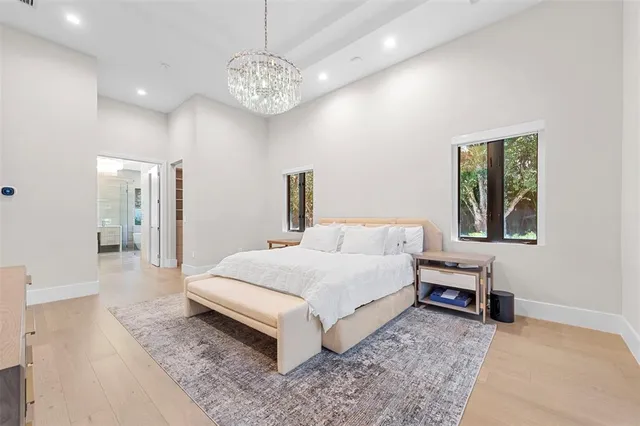 a spacious bedroom with a bed and a chandelier