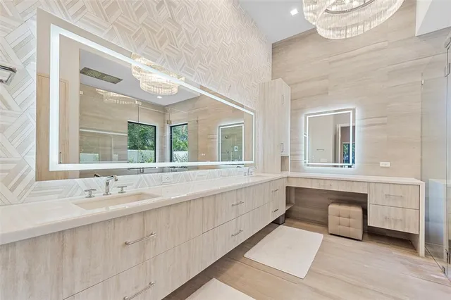 a bathroom with a sink and a large mirror next to a window