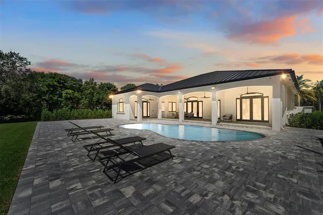 a view of a house with backyard and sitting area
