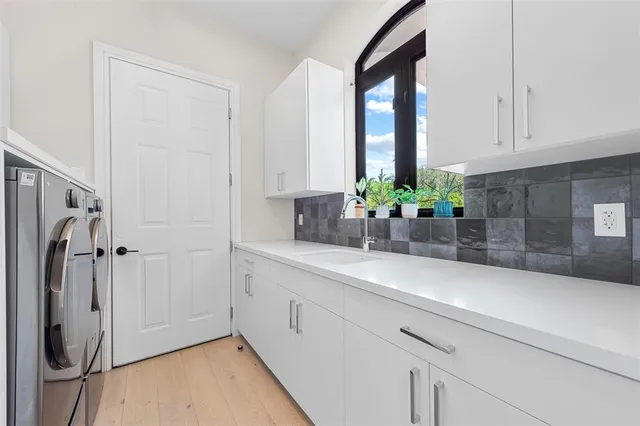 a kitchen with stainless steel appliances white cabinets and a window