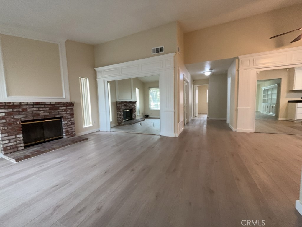 9263 Owari Lane Riverside, CA 92508 - Photo 2 of 17 an empty room with wooden floor a fireplace and windows