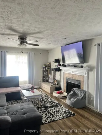 a living room with furniture a flat screen tv and a fireplace