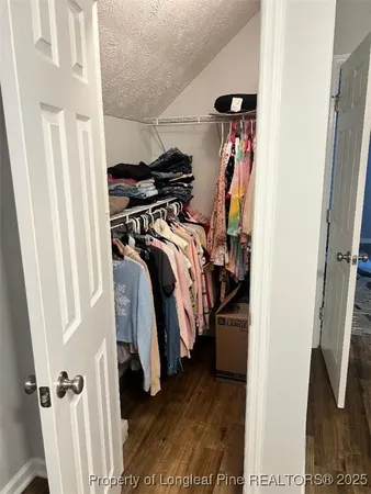 a view of walk in closet with clothes and shoes