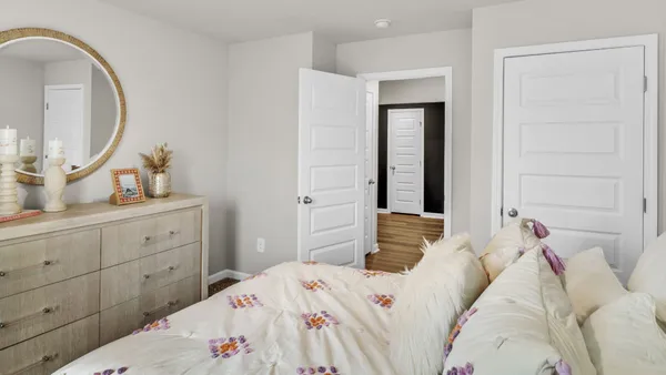 a bedroom with a bed and a mirror on dresser