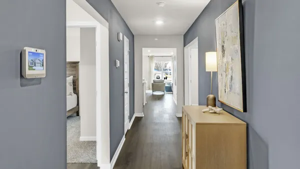 a view of a hallway with bathroom and wooden floor