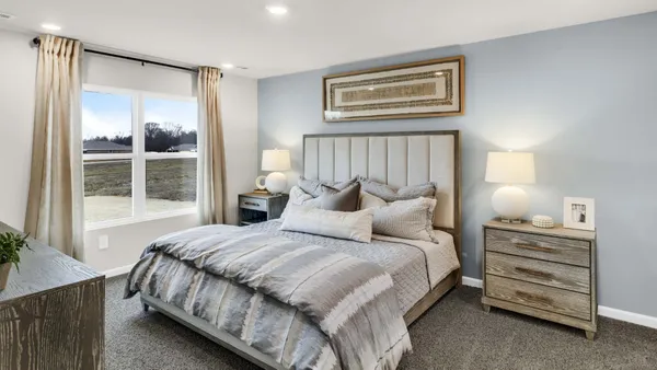 a bedroom with a bed and a large window