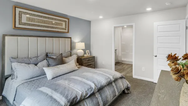 a spacious bedroom with a bed and a painting on the wall
