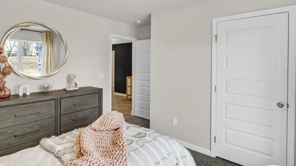 a bedroom with a bed and a mirror