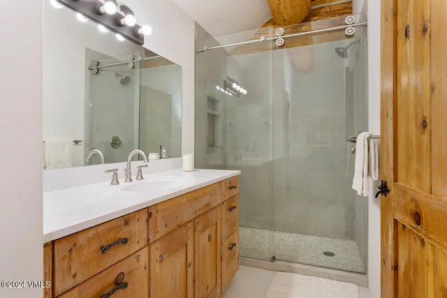a bathroom with a shower sink vanity and mirror
