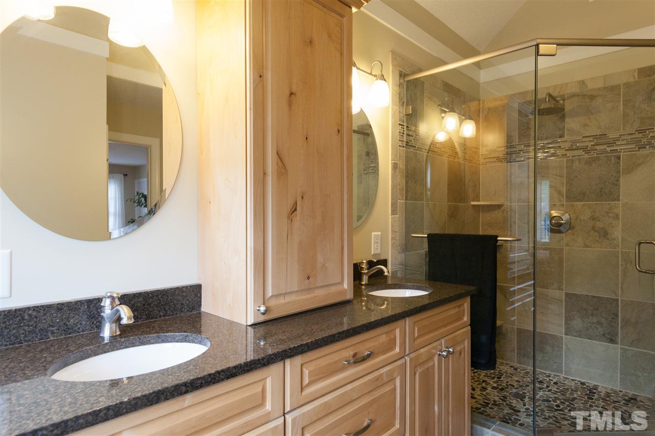 124 Huntsmoor Lane Cary, NC 27513 - Photo 12 of 25 a bathroom with a granite countertop sink a mirror and a shower