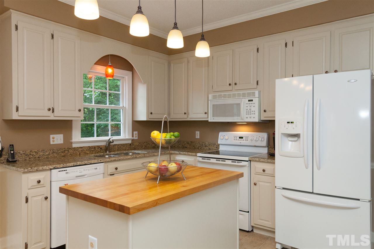 124 Huntsmoor Lane Cary, NC 27513 - Photo 6 of 25 a kitchen with stainless steel appliances granite countertop a sink a stove and a refrigerator