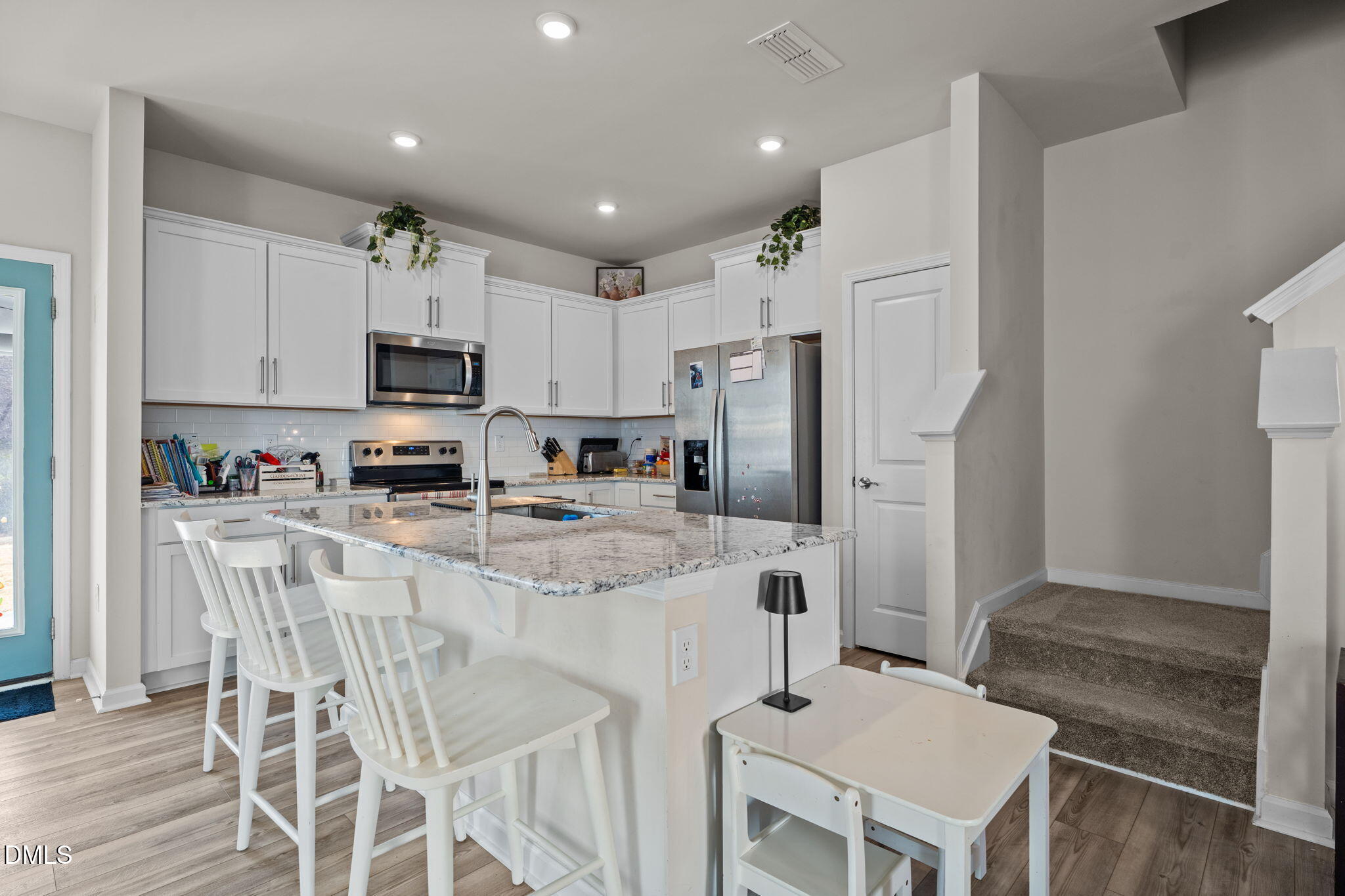 1572 Rhodes Pond Street Wendell, NC 27591 - Photo 14 of 42 a kitchen with stainless steel appliances a refrigerator stove microwave and white cabinets