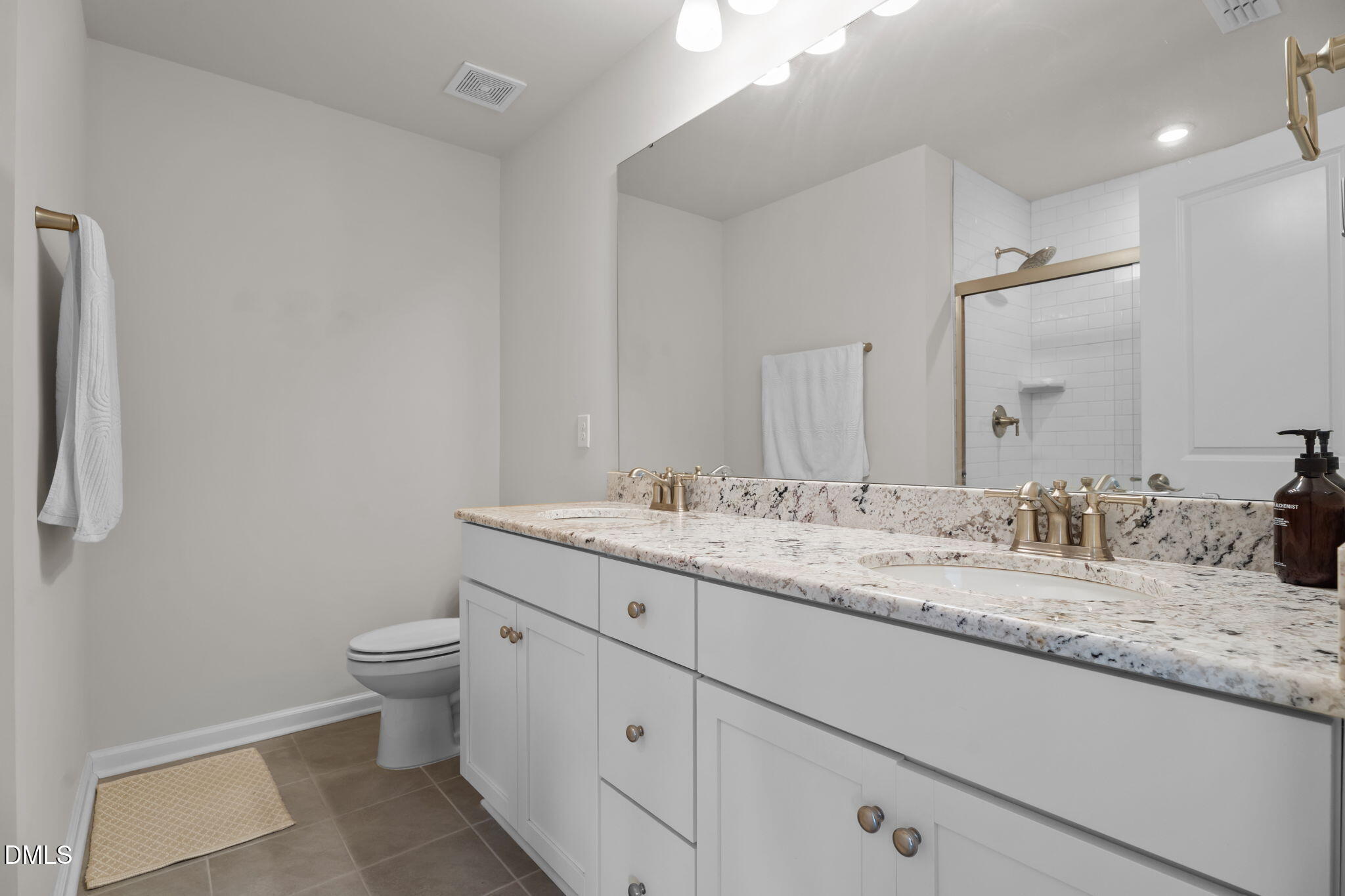 1572 Rhodes Pond Street Wendell, NC 27591 - Photo 28 of 42 a bathroom with a granite countertop sink a toilet and a mirror