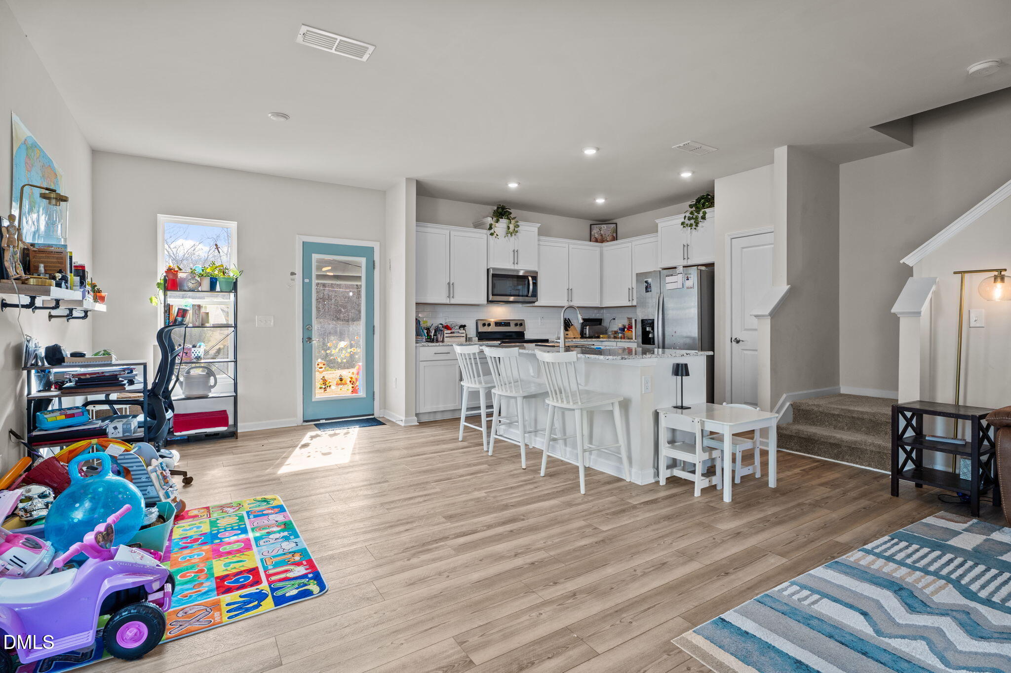 1572 Rhodes Pond Street Wendell, NC 27591 - Photo 8 of 42 a living room with furniture and a dining table with wooden floor